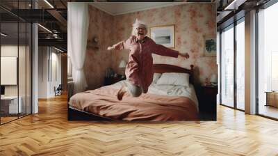 Stylish mature woman at her cozy home bedroom, full of energy jumping on the bed Wall mural