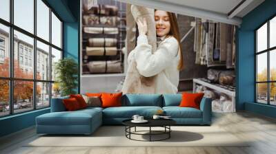 Woman hugging soft fluffy carpet in hardware store, home furniture buying concept Wall mural