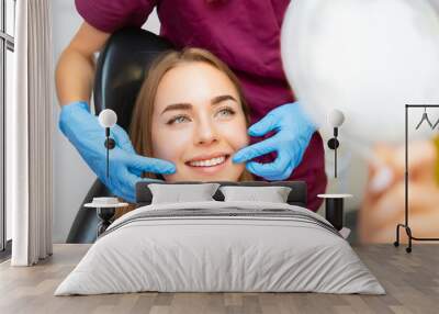 Dentist demonstrates the perfect smile of the patient after implatation of dental veneers or teeth whitening.  Wall mural