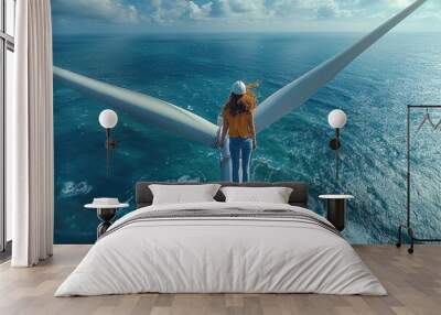 A daring individual balances on the edge of a wind turbine overlooking the ocean on a sunny day Wall mural