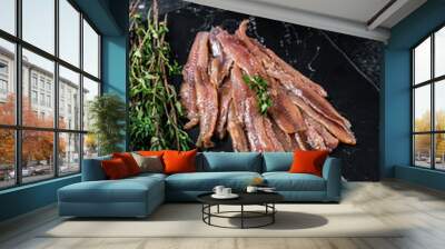 Anchovies fish fillet in Olive Oil. Black background. Top view Wall mural