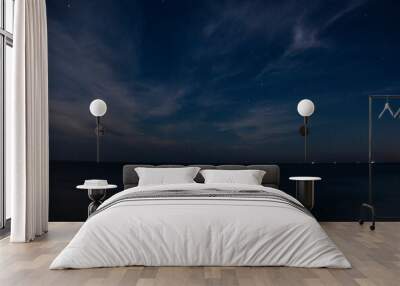 Starry sky with clouds at night in autumn with ships on the horizon Wall mural