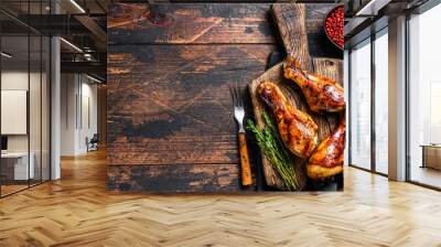 BBQ Grilled chicken drumsticks on a wooden cutting board. Dark wooden background. top view. Copy space Wall mural