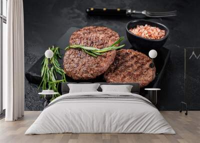 Beef burger patty cutlet for hamburger grilled on BBQ on marble board with rosemary. Black background. Top view Wall mural