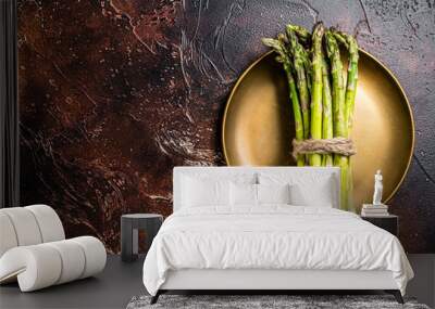 Bunch of Organic green asparagus in a plate. Dark background. Top view. Copy space Wall mural