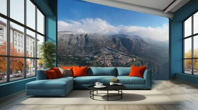 Aerial view of Delphi, Greece at sunrise, the Gulf of Corinth, Morning fog over mountains, hoarfrost on roofs, mountainside with layered hills beyond with rooftops in foreground Wall mural