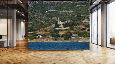 Seaview of the cathedral St.Nicholas in Komiza city at sunset - the one of numerous port towns in Croatia, green hills, mountain is on background Wall mural