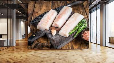 Fresh Raw cod loin fillet steaks on wooden board with butcher knife. wooden background. Top view Wall mural