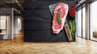 Fresh Raw new york strip beef steak on a butcher meat cleaver. Black wooden background. Top view. Copy space Wall mural