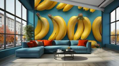 Fresh ripe bananas arranged neatly on a vibrant blue background for a colorful kitchen display or fruit market setting Wall mural