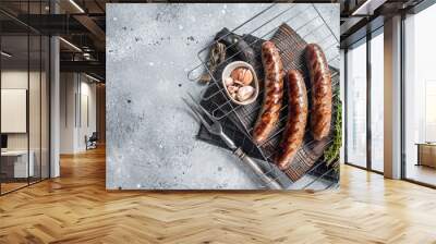 Grilled beef and lamb meat sausages with rosemary herbs on grill. Gray background. Top view. Copy space Wall mural