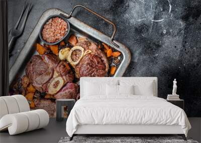 Italian braised veal shank steak Ossocbuco with vegetable sauce on steel tray. Black background. Top view. Copy space Wall mural