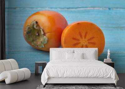 Delicious sweet persimmon on a wooden background. Wall mural