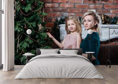 Mother and daughter decorate the Christmas tree. Merry Christmas and happy holidays. Wall mural