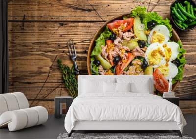 Nicoise salad with tuna,  tomatoes, olives, green beans, cucumber, soft boiled eggs and potato in a wooden bowl. wooden background. top view. Copy space Wall mural