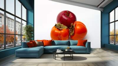 One red apple and two persimmons on a light background Wall mural