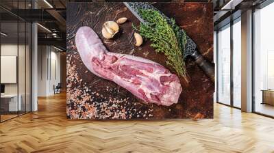 Raw beef tongue on kitchen table with herbs. Dark background. Top view Wall mural