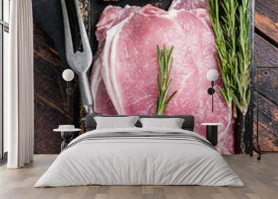 Ready for cooking raw pork chop steaks in a wooden tray with rosemary. Wooden background. Top view Wall mural