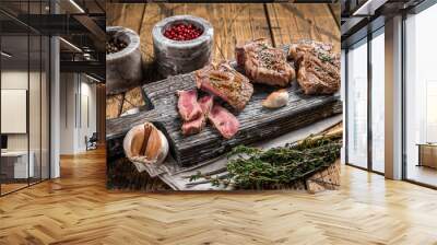 Roasted in BBQ lamb loin chops steaks, cutlets on a wooden board with herbs. Wooden background. Top view Wall mural