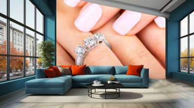 Beautiful female hands with diamond ring. Beautiful woman's nails with manicure. Gold ring with three diamonds. White gold. Wall mural