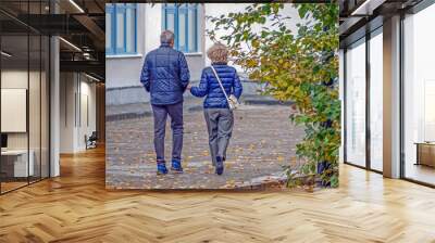 A man and a woman walk along the sidewalk on an autumn day Wall mural