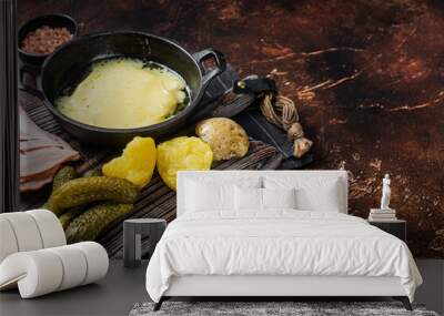 Swiss Raclette Melted cheese with boiled potato and ham on wooden board. Dark background. Top view. Copy space Wall mural