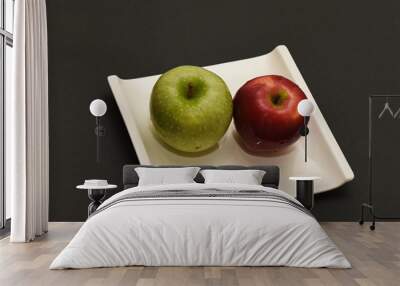 two fresh apples green and red are placed on a white ceramic plate Wall mural