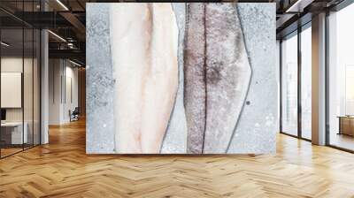 Two raw haddock fish fillets on kitchen table. Gray background. Top view Wall mural