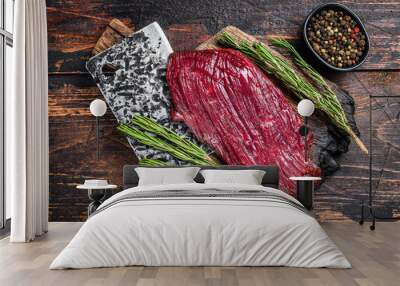 Venison raw meat steak on a cuuting board with rosemary. Black background. Top view Wall mural