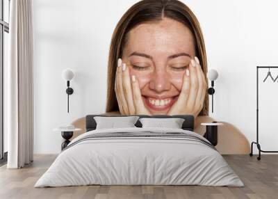 beautiful middle-aged smiling woman without makeup lying on her hands on white background Wall mural