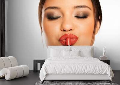 closeup of a young beautiful woman applies lipstick Wall mural