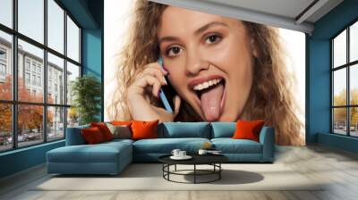 crazy young girl talking on the phone with tongue out Wall mural