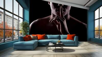 frican man with the face in the shadow holding finger on lips Wall mural