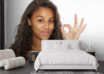 happy young dark-skinned woman showing gesture for delicious on white background Wall mural