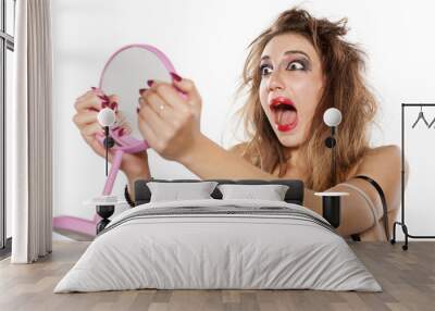 shocked young woman with bad makeup and messy hair looking at herself in the mirror Wall mural