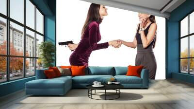 two young woman shake hands warmly with guns behind Wall mural