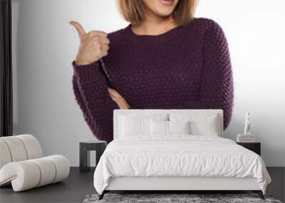 young smiling woman in a purple sweater and jeans showing thumbs up Wall mural