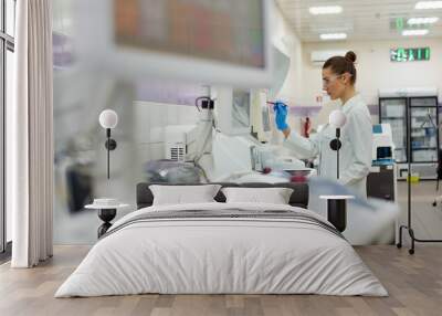 A female scientist controls the operation of devices for laboratory research. Modern laboratory technologies. Medical research centrifuge. Wall mural