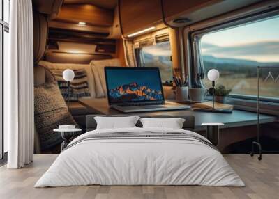 A laptop on a desk in a modern motorhome, interior view, with a beautiful landscape visible outside the window. Cinematic lighting enhances the scene. Wall mural