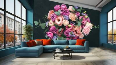 Beautiful bouquet of pink purple peonies, roses and eucalyptus isolated on black background. Top view Wall mural