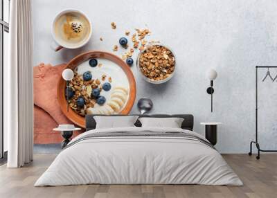 Breakfast granola cereal bowl with yogurt and fruits on grey concrete background. Top view copy space. Terracotta color concept Wall mural