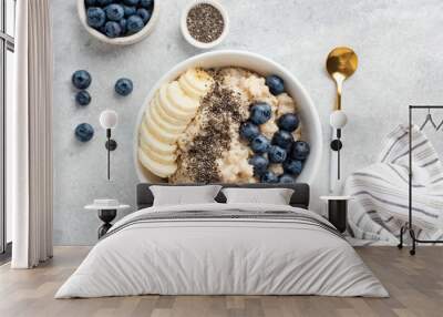 breakfast oatmeal porridge with banana, blueberries, chia seeds on grey concrete background. table t Wall mural