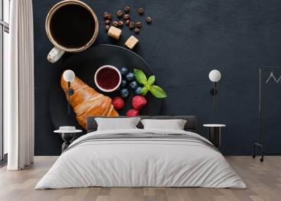 Croissant, fresh berries, jam and cup of black coffee on black background. Top view, copy space for text Wall mural