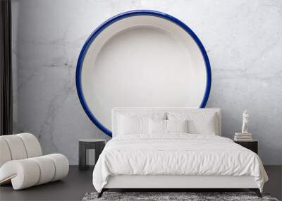 Empty white ceramic plate with blue rim on white marble table background Wall mural