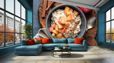 Oatmeal porridge with apple and cinnamon in bowl, top view. Healthy breakfast meal Wall mural