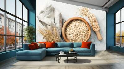 Rolled oats in wooden bowl and ears of wheat on grey background. Table top view. Healthy eating, healthy lifestyle, gluten free diet concept Wall mural