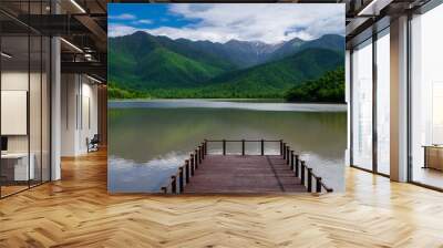 Pier on the lake on a background of mountains and blue sky Wall mural