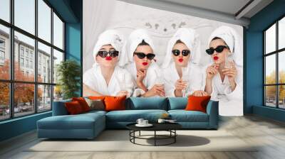 Young, beautiful women in bathrobes and glasses enjoying bachelorette party at spa or hotel and eating donuts, happy multiracial girlfriends celebrating bachelorette party Wall mural