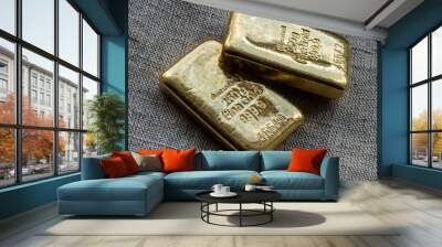 Two cast gold bars weighing 250 grams against the background of the texture of coarse cloth. Wall mural