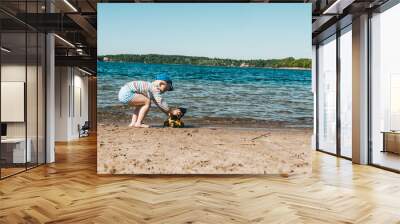 A child plays with a toy tractor on the shore of a lake Wall mural